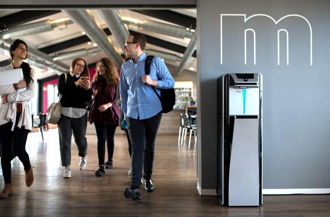people walking while talking and water cooler on the right